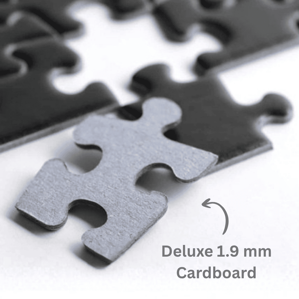 Close-up of metal jigsaw puzzle pieces on a white surface, with one front piece in sharp focus and blurred pieces behind it. Text reads 'Deluxe 1.