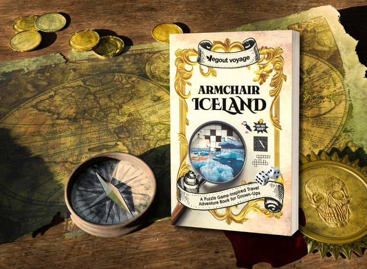 Book titled 'Armchair Iceland' on a map with coins and a compass