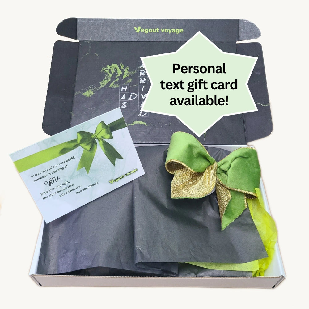 Vegout Voyage gift box with green bow and text card on a white background
