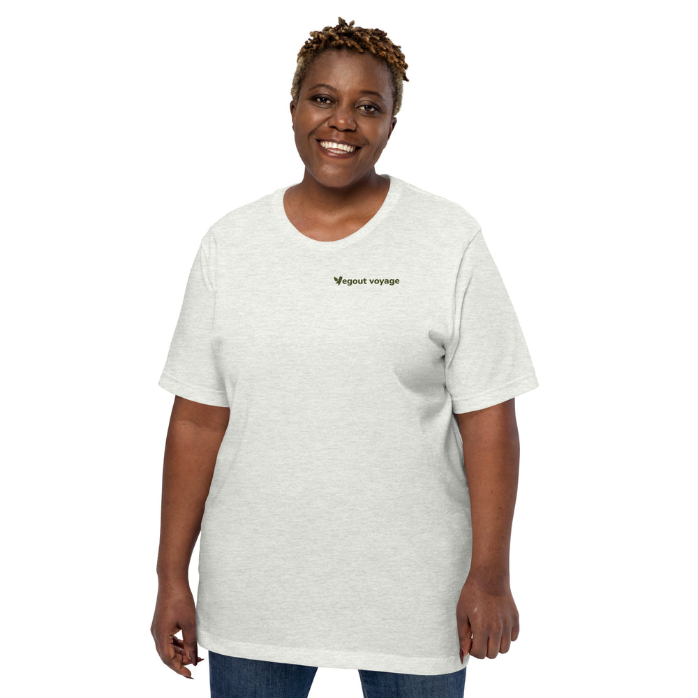 Smiling woman modeling an ash-colored "Vegout Voyage" t-shirt, hands by her sides.