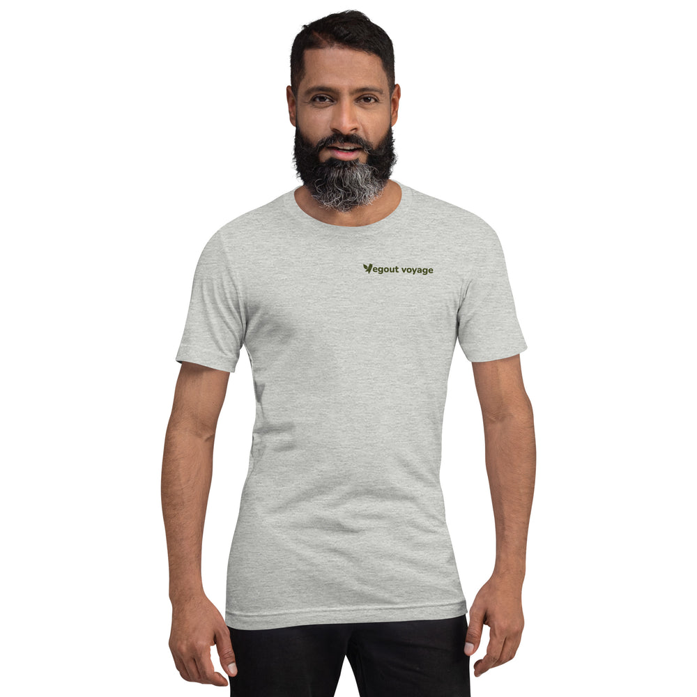 Bearded man modeling a light heather gray "Vegout Voyage" t-shirt, facing forward with hands relaxed.